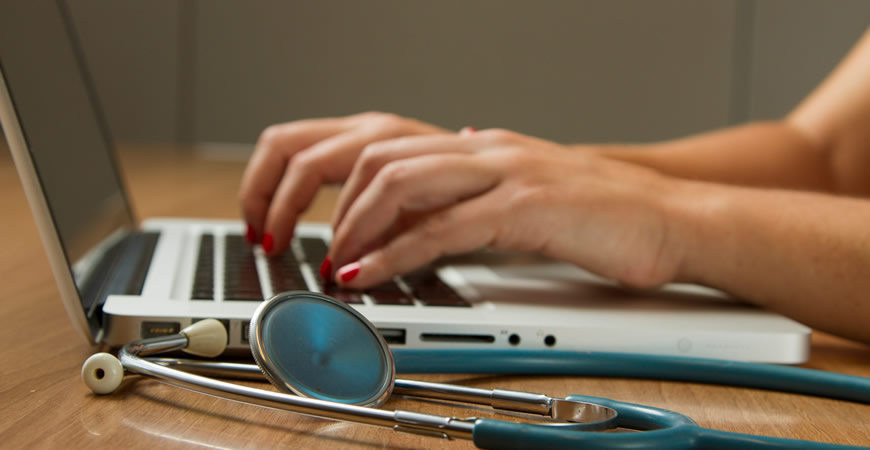 Laptop with stethoscope on desk